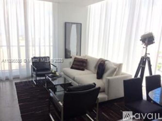 A living room with a white couch and a black coffee table.