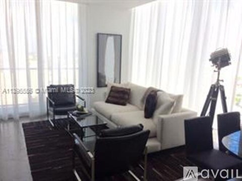 A living room with a white couch and a black coffee table.