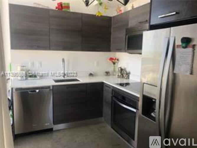 A modern kitchen with stainless steel appliances and a white fridge.