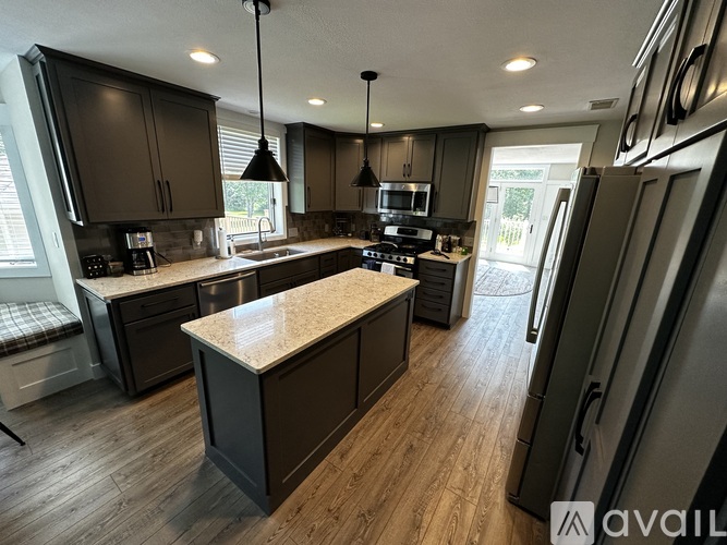 A modern kitchen with dark wood cabinets and a central island.