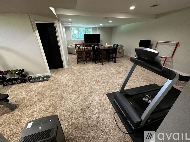 A living room with a treadmill in the foreground.
