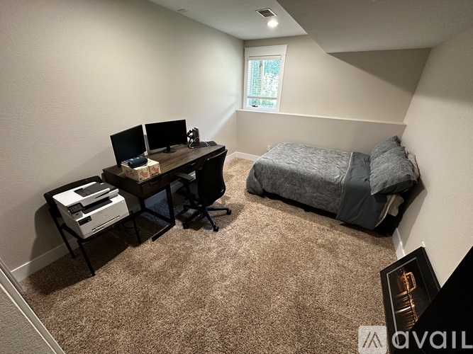 A bedroom with a bed, desk, and chair.