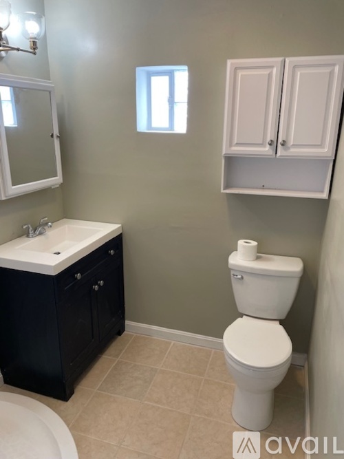 A white toilet sits next to a sink in a bathroom.