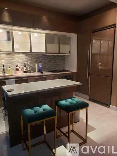 A kitchen with a bar stool in front of a counter.