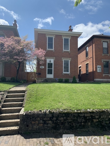A red brick house with a white door and windows.