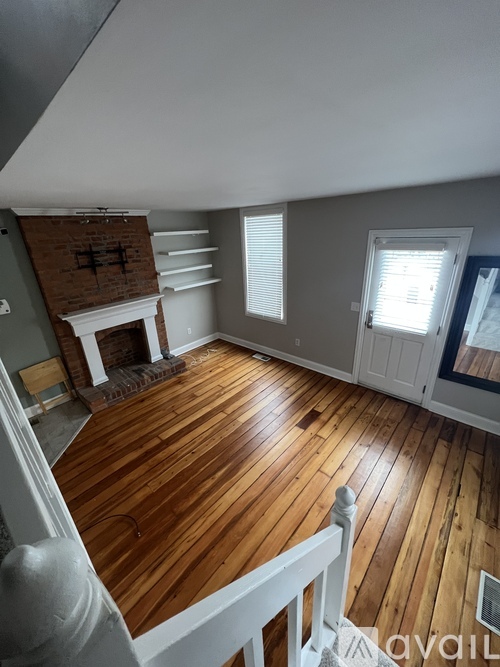 A room with wooden floors and a fireplace.