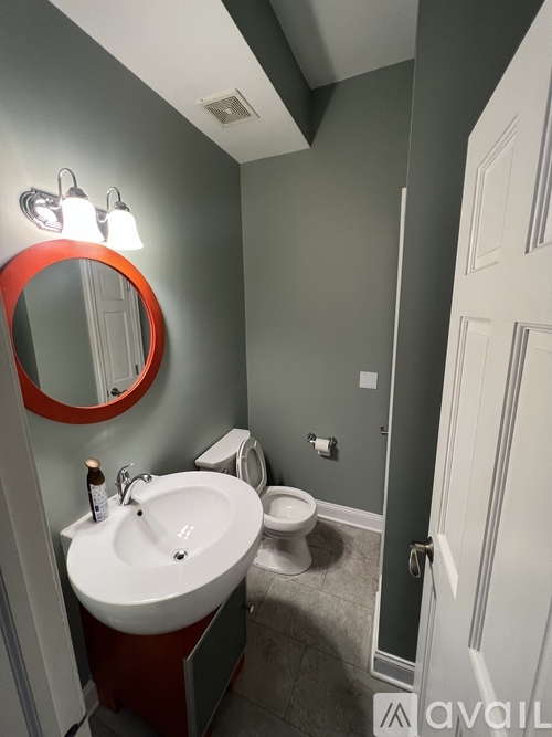 A bathroom with a red mirror and a white sink.