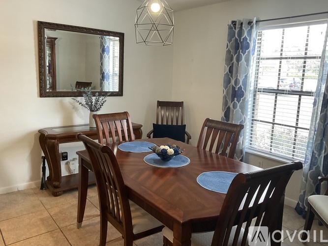 A dining room with a wooden table and chairs.