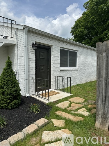A white house with a black door and a small porch.