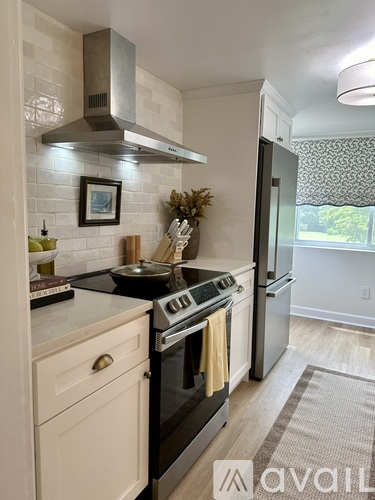 A kitchen with a black stove top oven and a fridge.