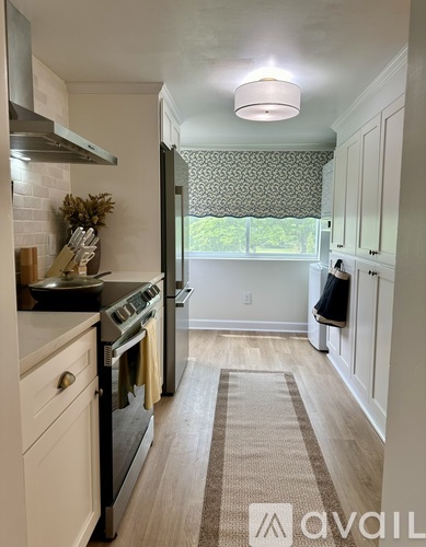 A kitchen with a black stove top oven and white cabinets.