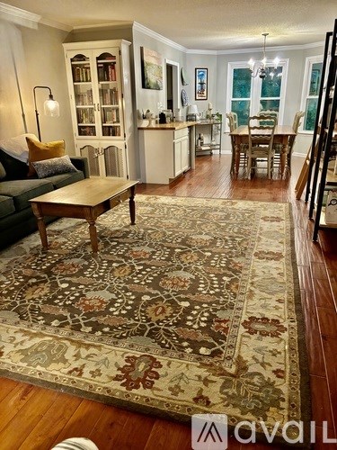 A living room with a rug on the floor and a couch.