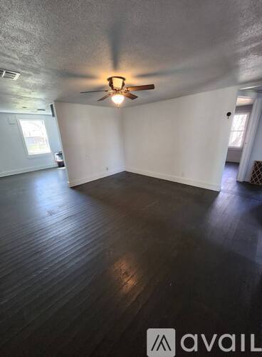 A room with wooden flooring and a ceiling fan.