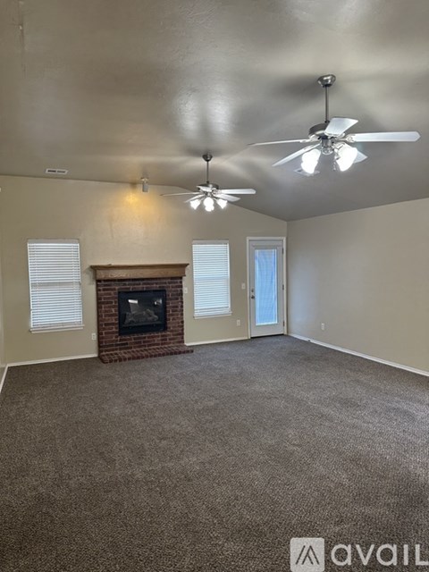 A living room with a fireplace and two ceiling fans.