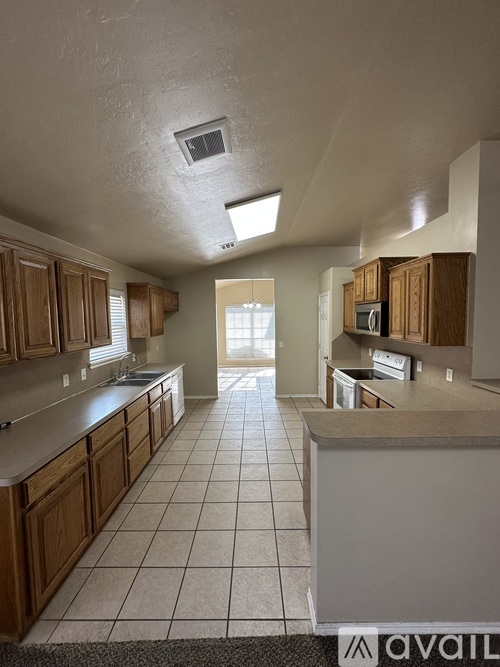 A kitchen with wooden cabinets and a tiled floor.