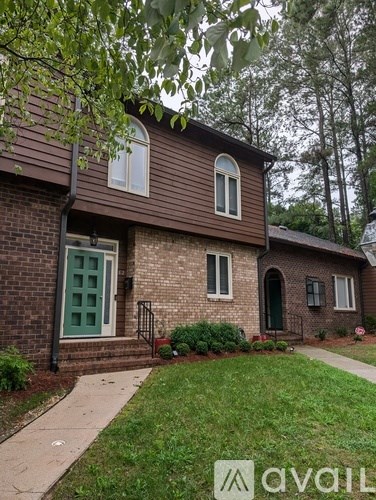 A house with a green door and a sign that says "avail" in front of it.