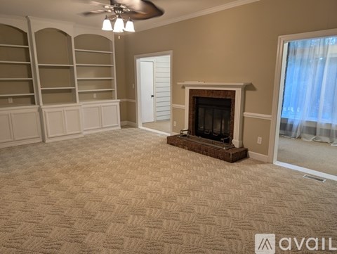 A living room with a fireplace and a carpet.