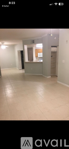 A spacious room with a tiled floor and a door on the right side.