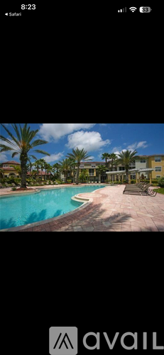 A pool surrounded by palm trees and buildings.