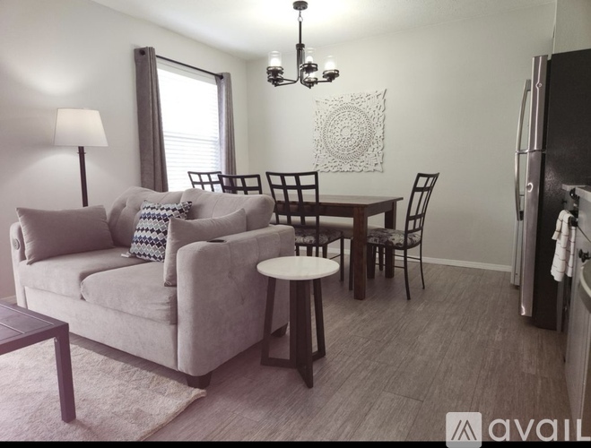 A living room with a couch, chairs, and a table.
