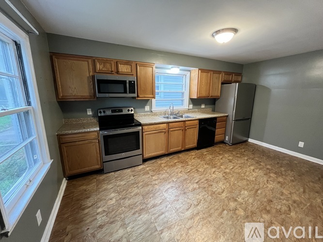 A kitchen with wooden cabinets and a granite countertop.