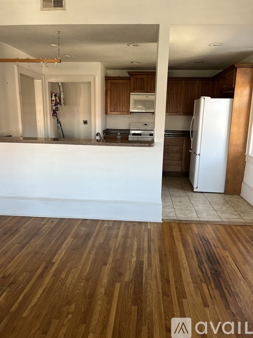 A kitchen with wooden floors and white appliances.