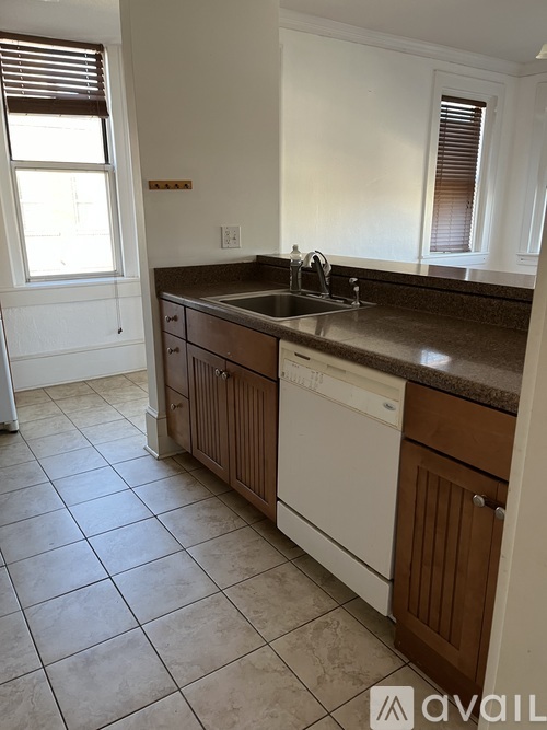 A kitchen with white cabinets and a brown countertop.