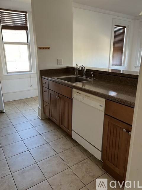 A kitchen with white cabinets and a brown countertop.