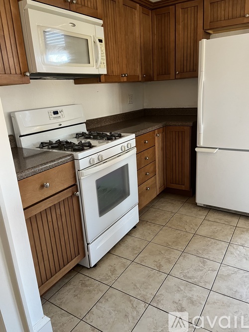 A kitchen with a white stove and refrigerator.