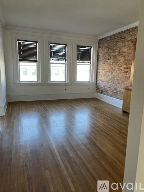 A room with wooden floors and a brick wall.