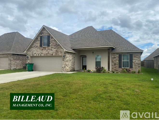 A house with a stone facade and a green lawn in front.