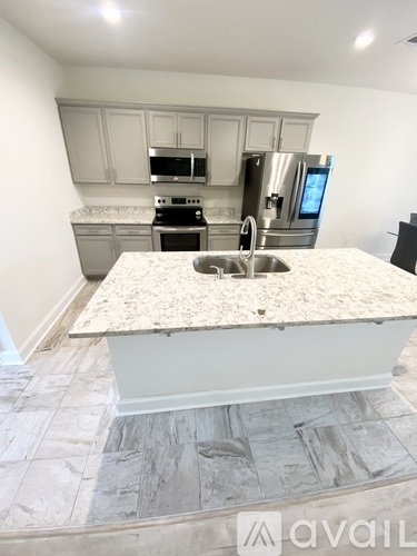 A kitchen with a granite countertop and stainless steel appliances.
