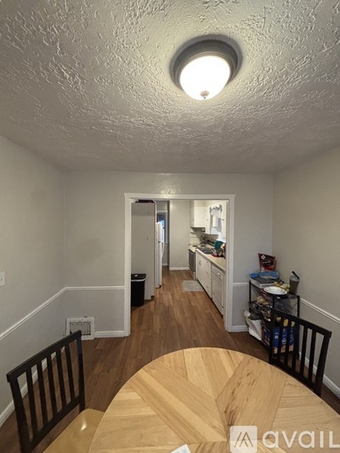 A kitchen area with a wooden table and chairs.