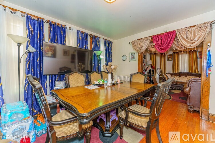 A dining room with a wooden table and chairs.