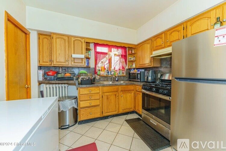 A kitchen with wooden cabinets and a stainless steel refrigerator.