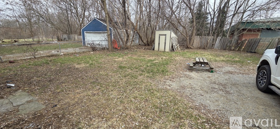 A yard with a shed and a car.