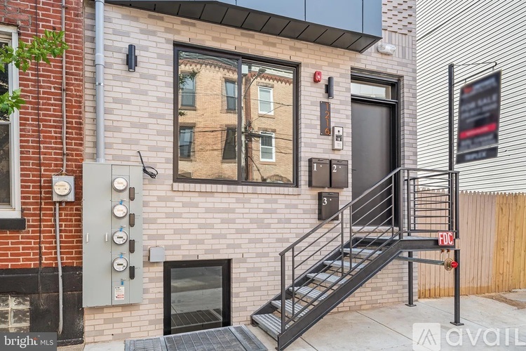 A brick building with a staircase leading to a door.
