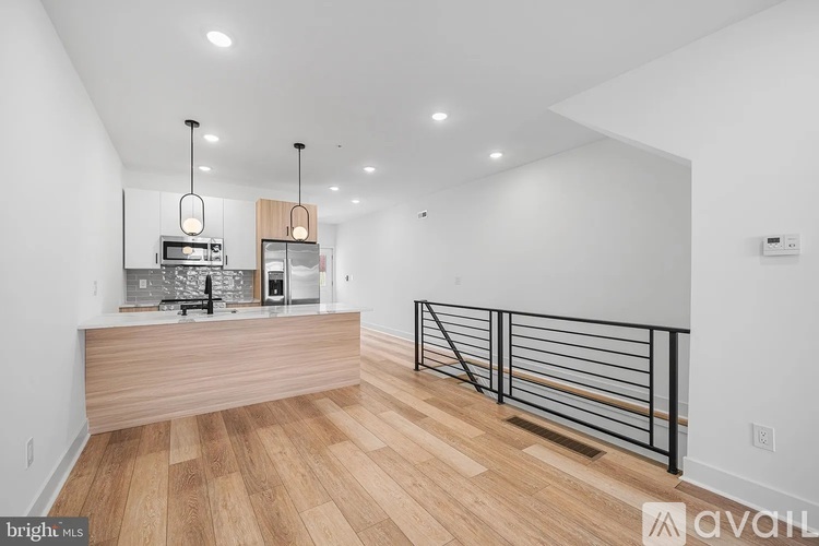 A modern kitchen with wooden floors and white walls.
