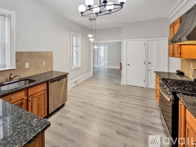 A kitchen with wooden cabinets and a black granite countertop.