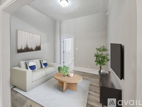 A living room with a couch, a coffee table, a plant, and a television.