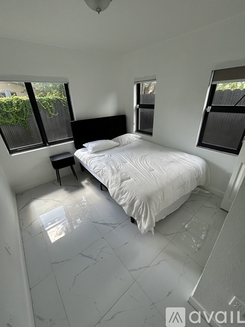 A bedroom with a large bed and a window.