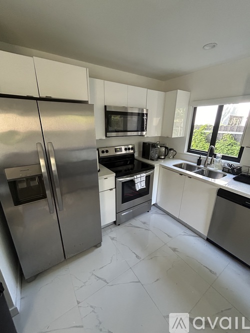 A kitchen with white cabinets and stainless steel appliances.