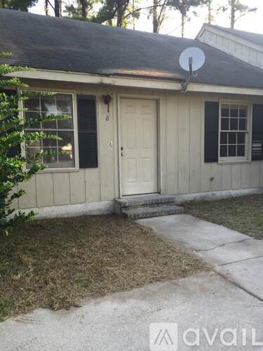 A house with a white door and black shutters is for sale.
