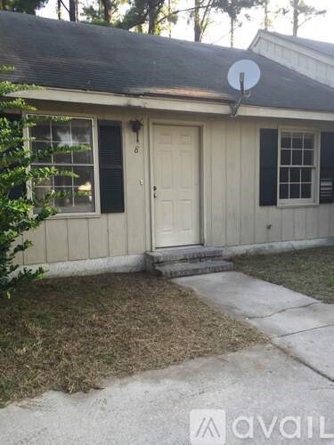 A house with a white door and black shutters is for sale.