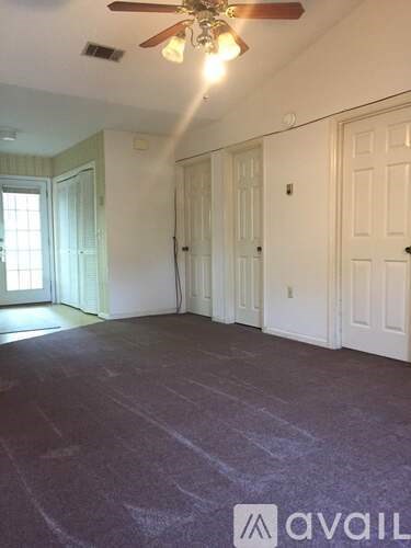 A room with a ceiling fan and a window.
