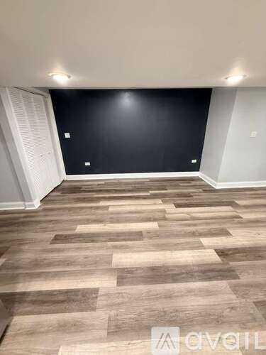 A hallway with wooden flooring and a bench on the right side.