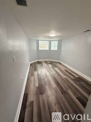 A kitchen with a white table and wooden flooring.
