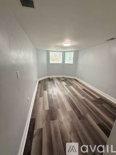 A kitchen with a white table and wooden flooring.