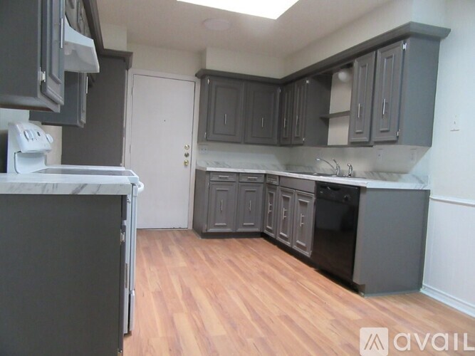 A kitchen with dark wood cabinets and a white fridge.