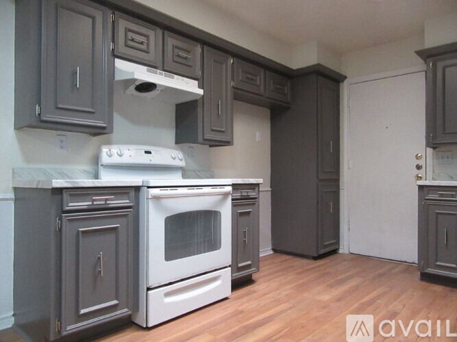 A kitchen with a white stove top oven and a white dishwasher.